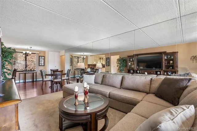 a living room with furniture kitchen view and a large window