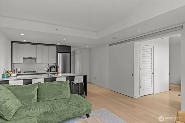 a living room with stainless steel appliances granite countertop furniture a couch and a view of kitchen living room