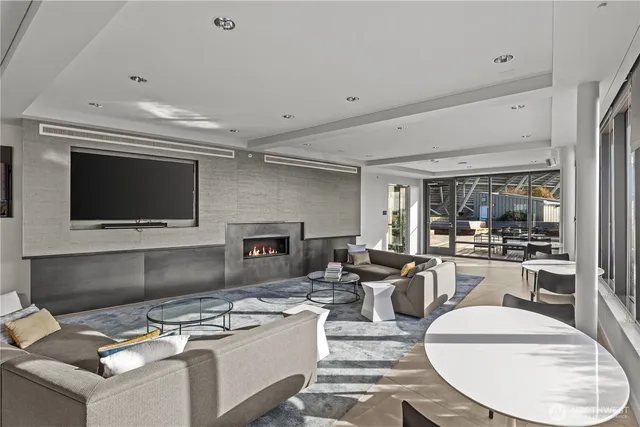 a living room with furniture large windows and a floor to ceiling window