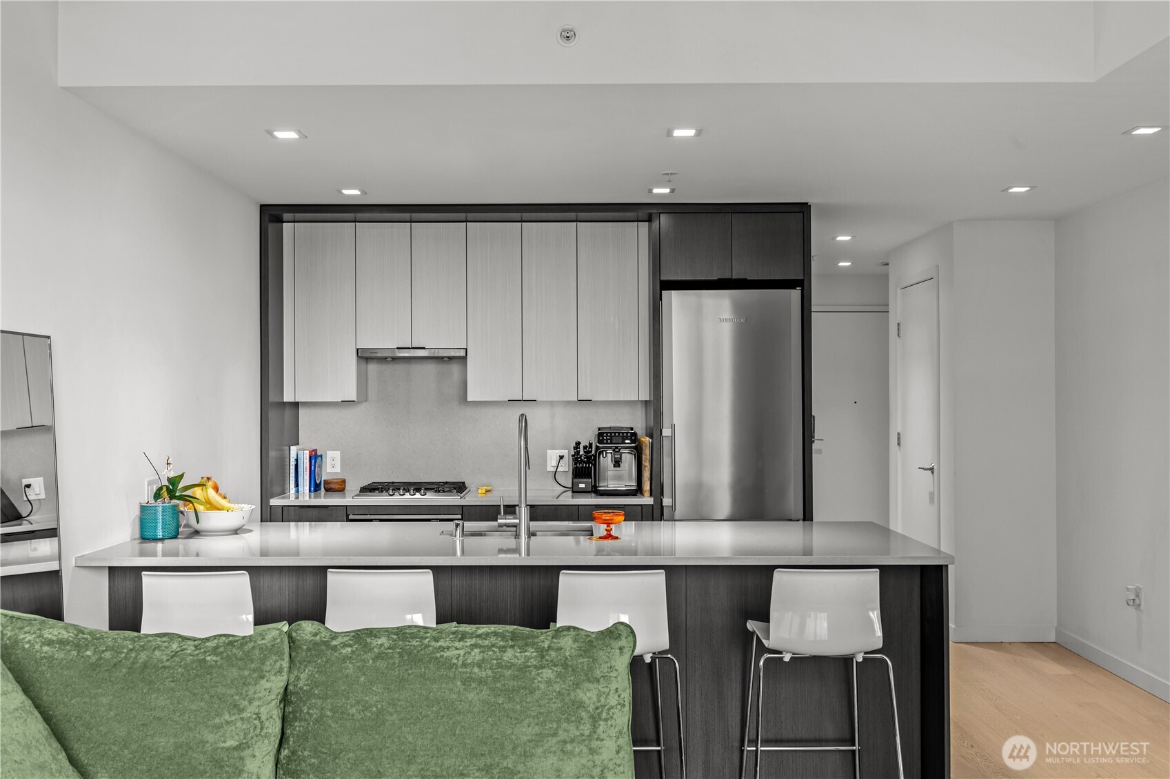 590 1st Avenue South, Unit 715 Seattle, WA 98104 - Photo 7 of 39 a kitchen with kitchen island cabinets and a refrigerator