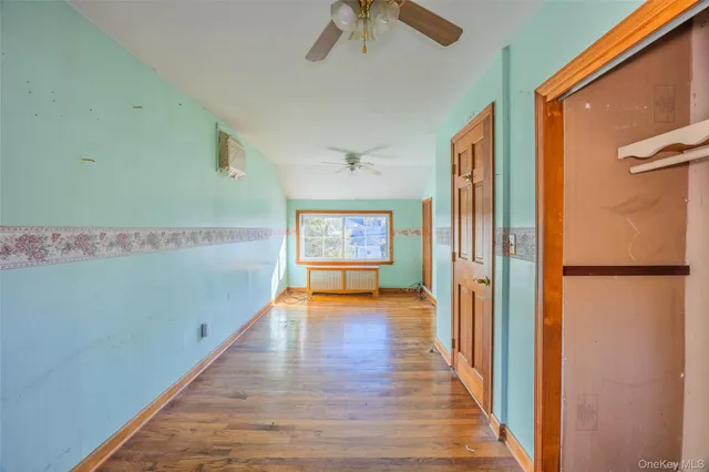 a view of a hallway with wooden floor and furniture