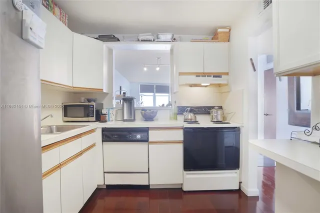 a kitchen with kitchen island white cabinets and white appliances