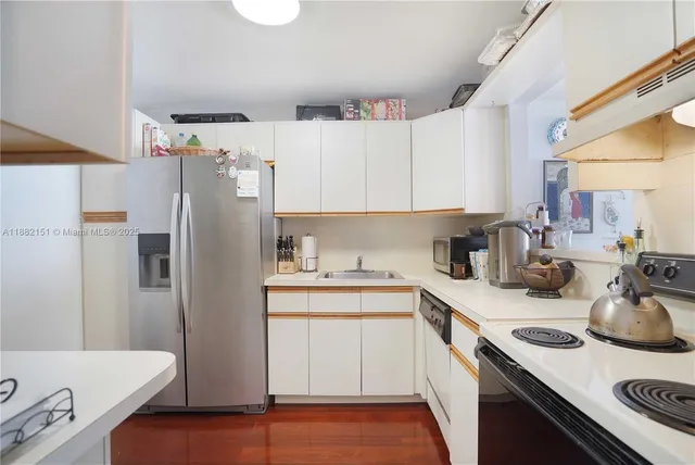 a kitchen with a sink a refrigerator and cabinets