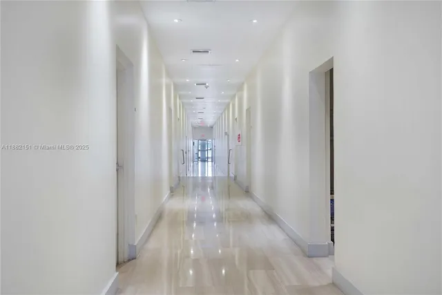 a view of a kitchen with stainless steel appliances white cabinets and a window
