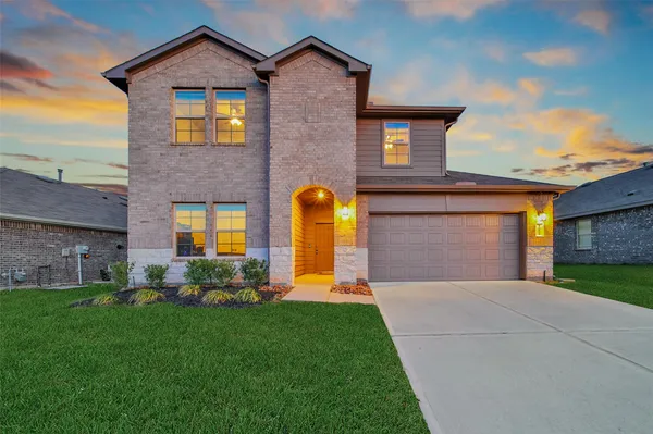 a front view of a house with a yard and garage