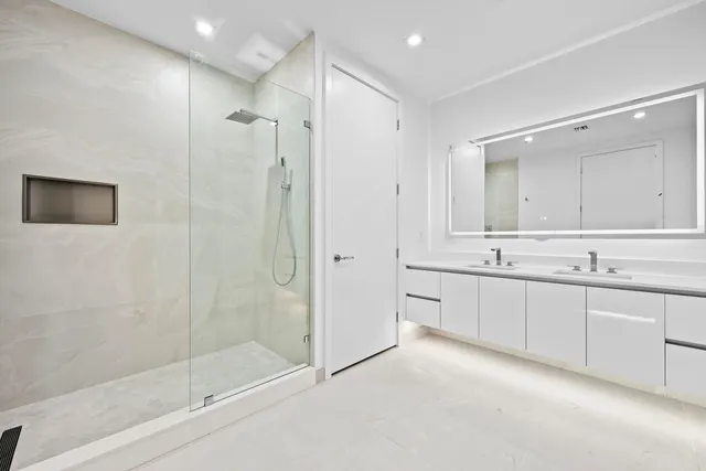 a bathroom with a shower sink and mirror