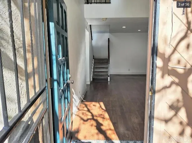 a view of a hallway with wooden floor and glass door