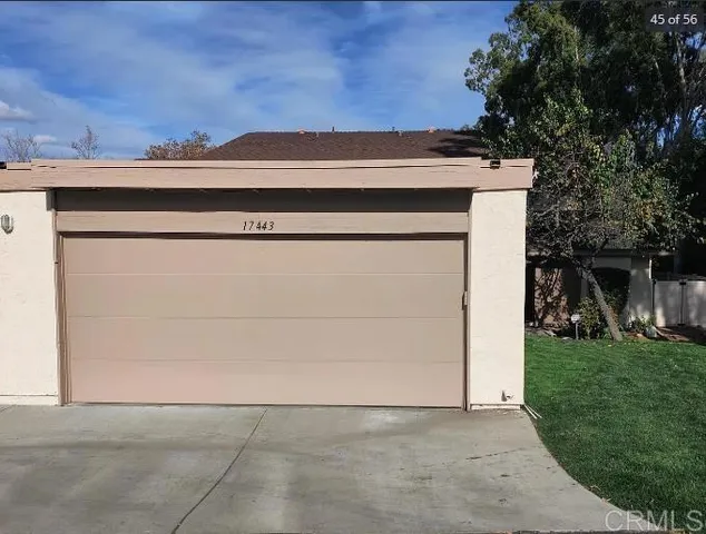 a view of a house with a yard and a large tree