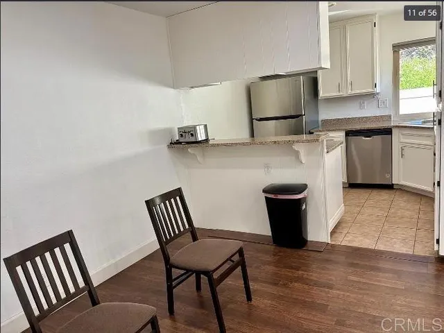 a kitchen with a chair and wooden floor