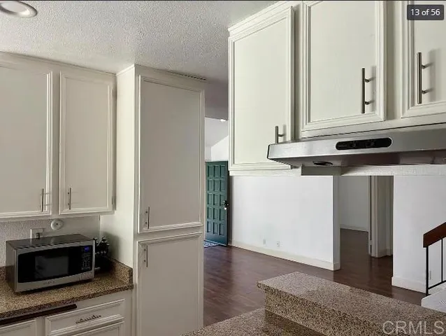 a kitchen with stainless steel appliances granite countertop a refrigerator and a stove