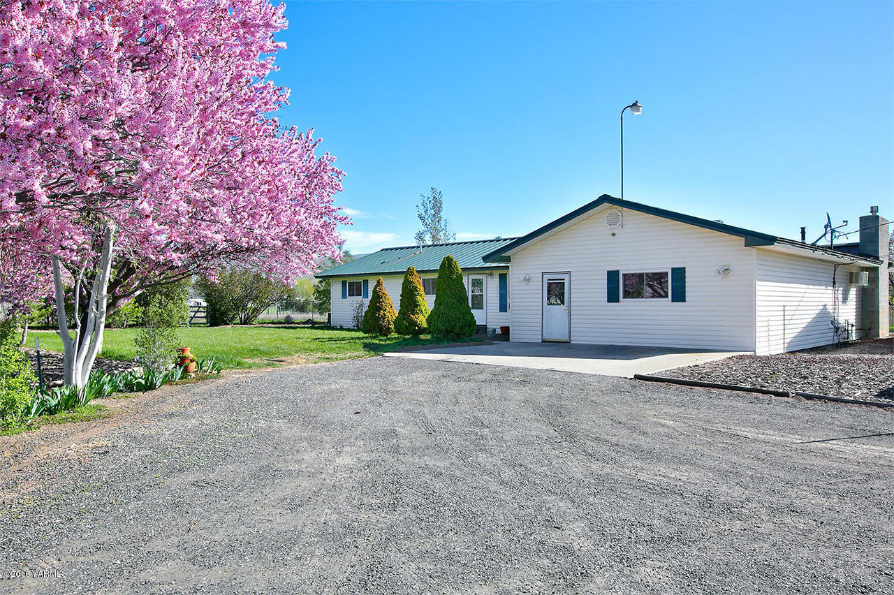 a view of a house with a yard and large tree