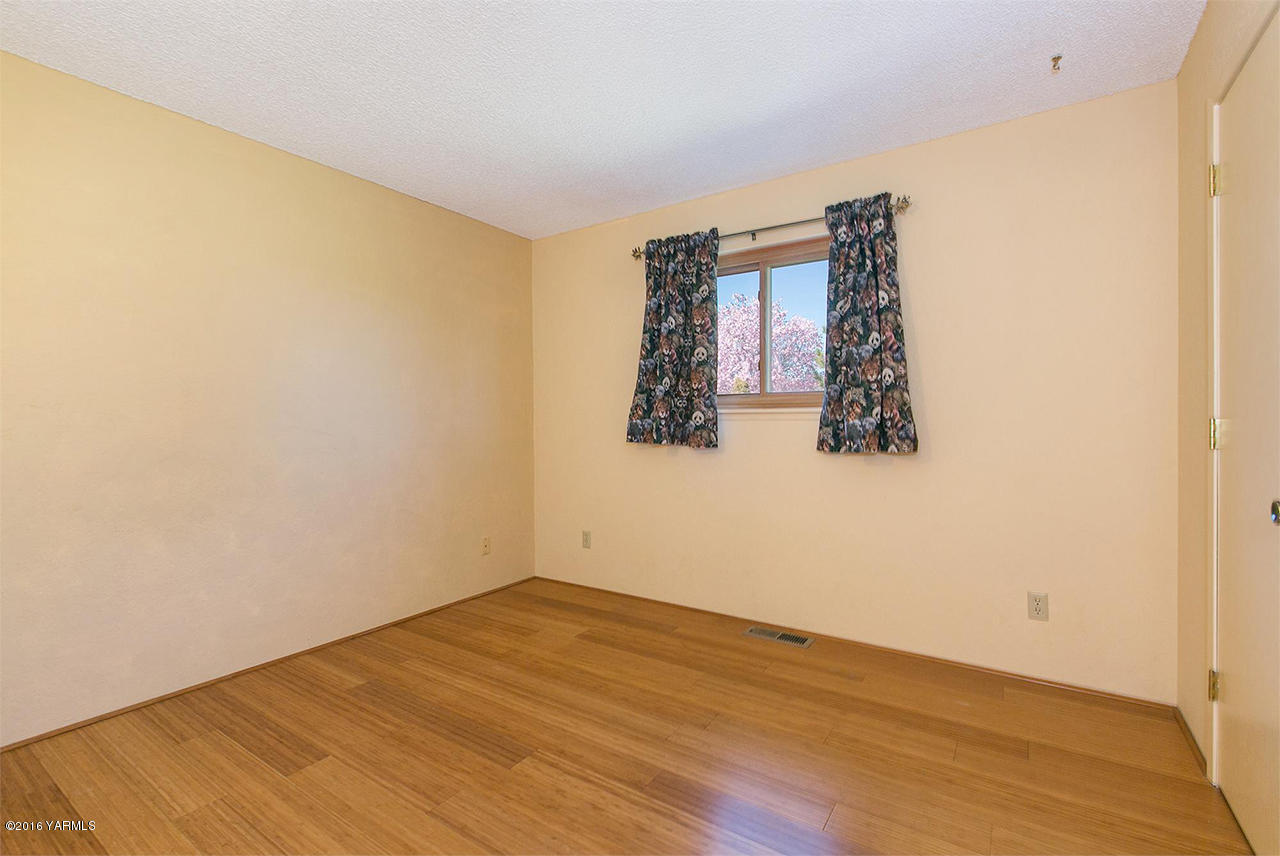 71 Sheep Company Road Selah, WA 98942 - Photo 11 of 19 an empty room with wooden floor and fan