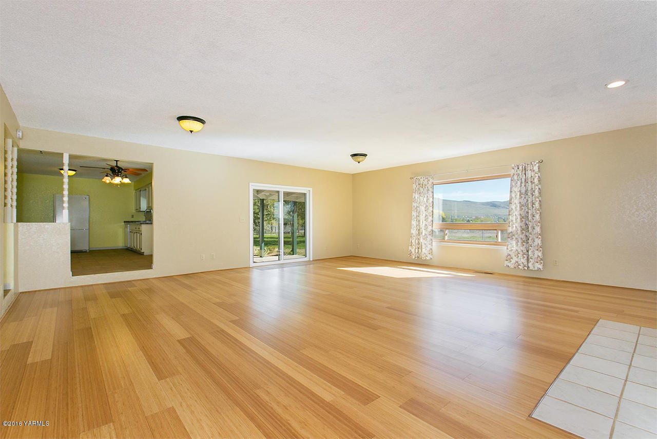 71 Sheep Company Road Selah, WA 98942 - Photo 4 of 19 a view of an empty room with wooden floor and a window