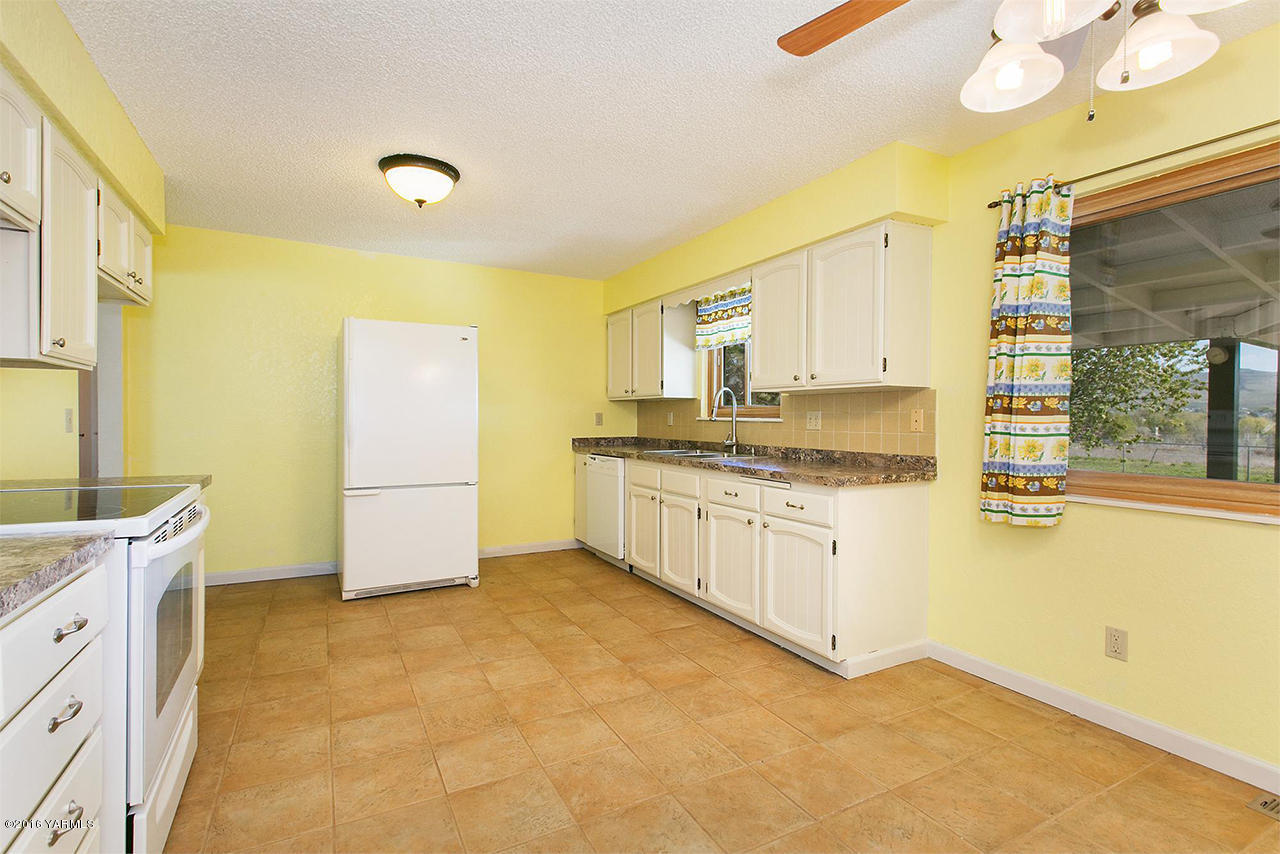 71 Sheep Company Road Selah, WA 98942 - Photo 5 of 19 a kitchen with granite countertop a sink and white cabinets