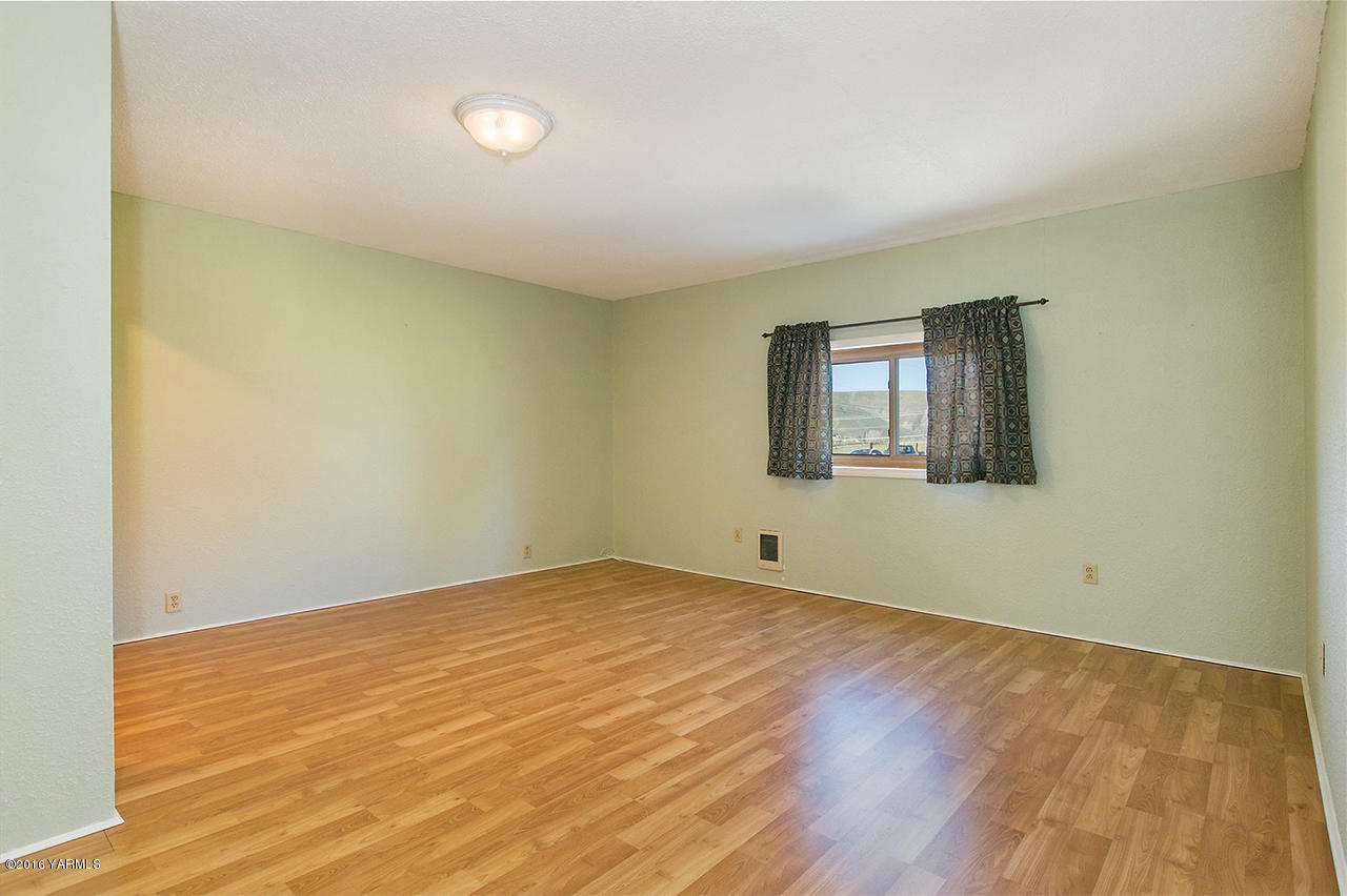 71 Sheep Company Road Selah, WA 98942 - Photo 9 of 19 an empty room with wooden floor and windows