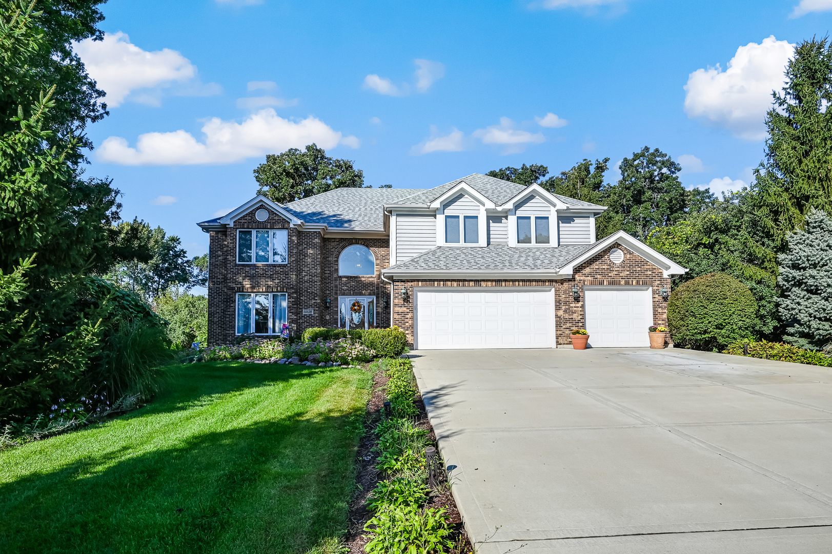 8826 Carlisle Court Darien, IL 60561 - Photo 1 of 36 a front view of a house with a yard and garage