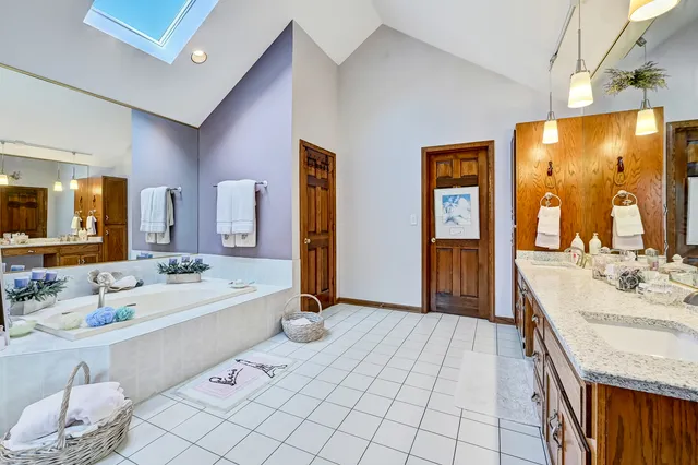 a spacious bathroom with a double vanity sink and a mirror