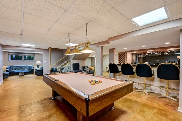 a living room with stainless steel appliances kitchen island granite countertop a table chairs and a view of living room
