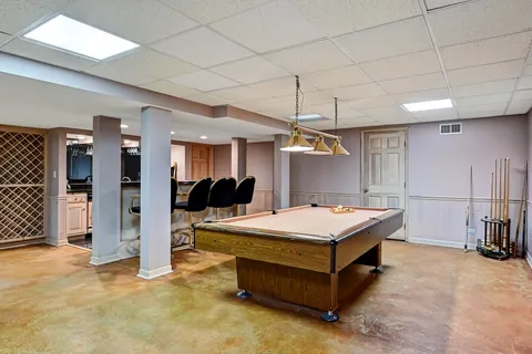 a room with pool table and windows