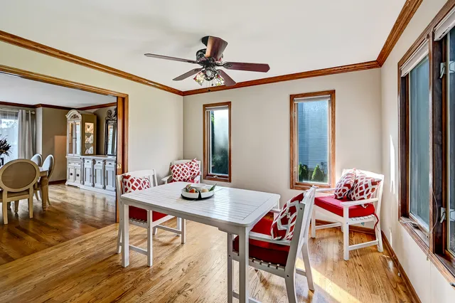 a dining room with furniture a chandelier and wooden floor