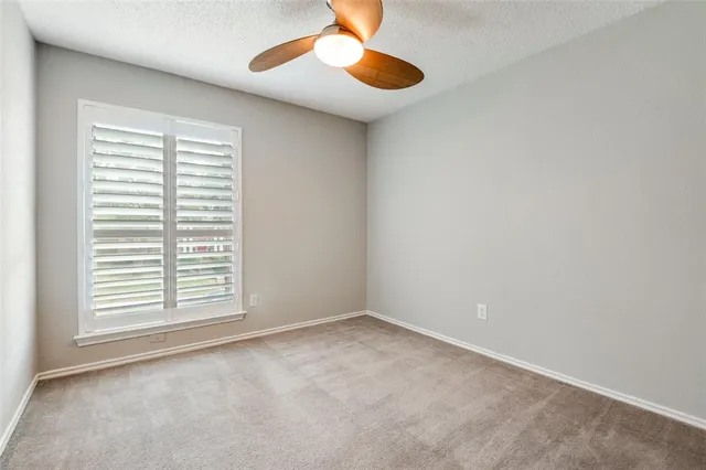 an empty room with a window and a kitchen space