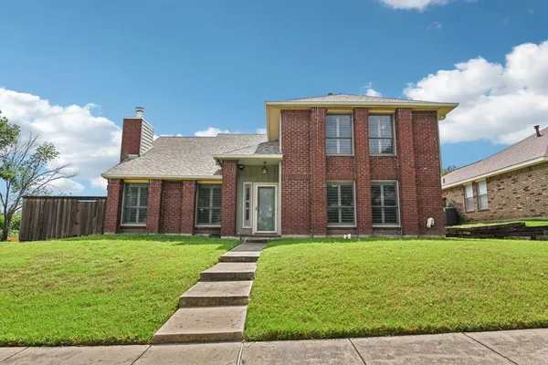 a view of a brick house with a yard