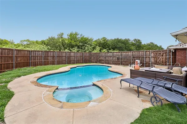 a view of swimming pool with outdoor seating and yard in back