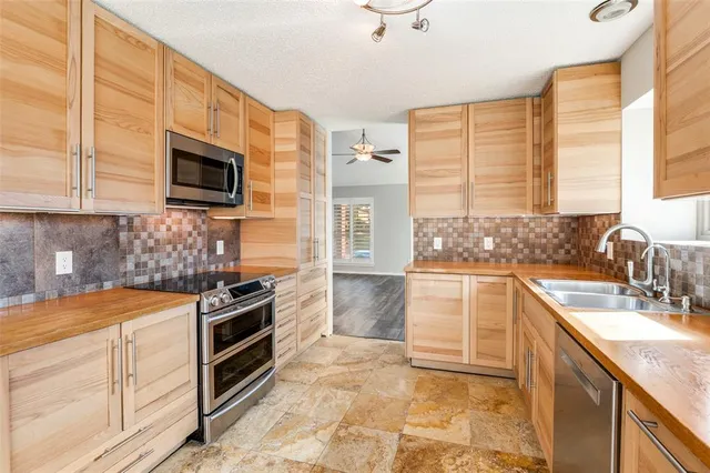 a kitchen with stainless steel appliances a stove sink microwave and cabinets