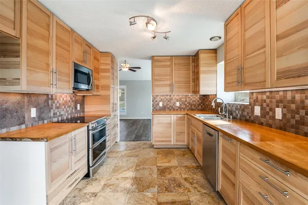 a large kitchen with stainless steel appliances granite countertop a sink and a stove