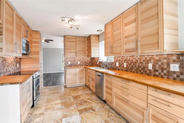 a large kitchen with kitchen island granite countertop a sink and a stove