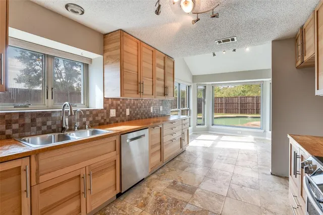 a large kitchen with kitchen island granite countertop a large window and a sink