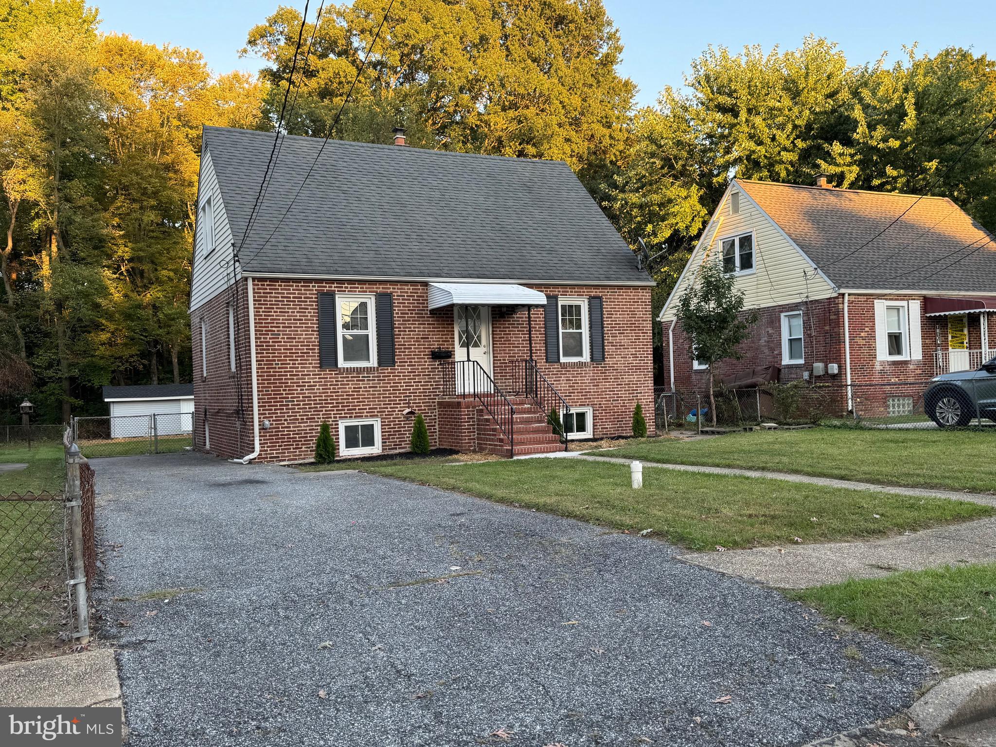 a front view of a house with a yard and trees
