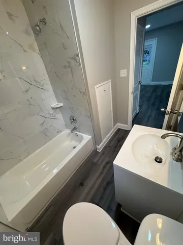 an empty room with wooden floor and entryway