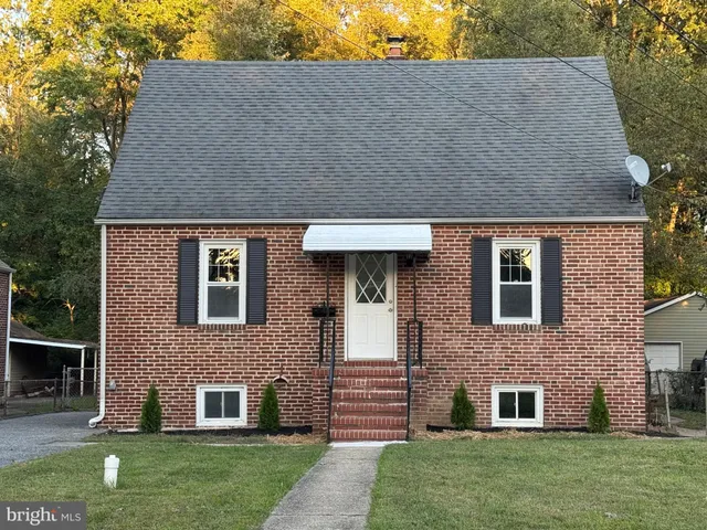 a view of a yard in front of a house with large trees