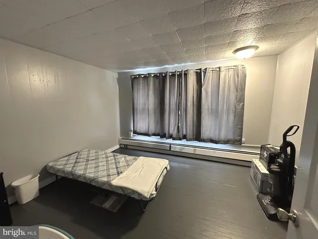 a bedroom with a bed and large windows