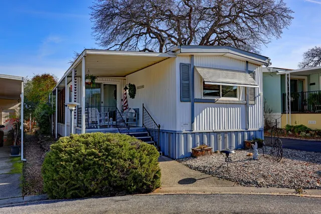 a view of a house with a small yard and potted plants