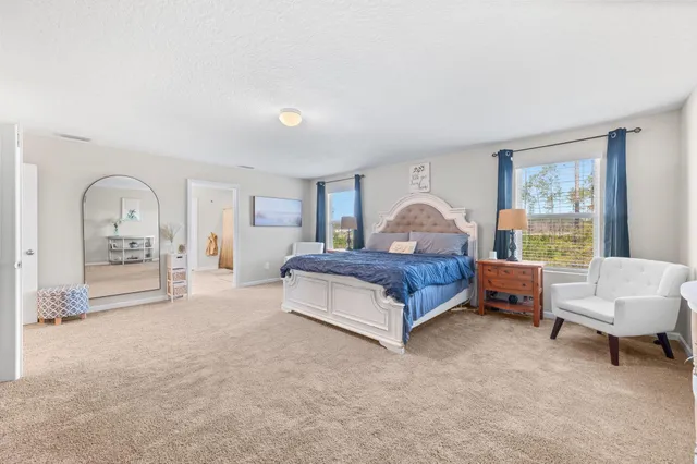 a spacious bedroom with a bed and a couch