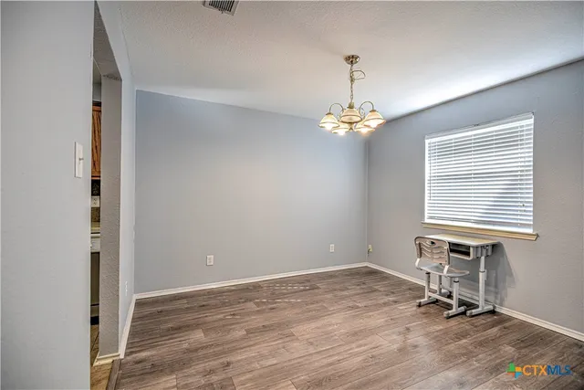 a view of a room with wooden floor and windows