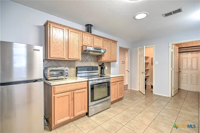 a kitchen with stainless steel appliances granite countertop a refrigerator sink and cabinets