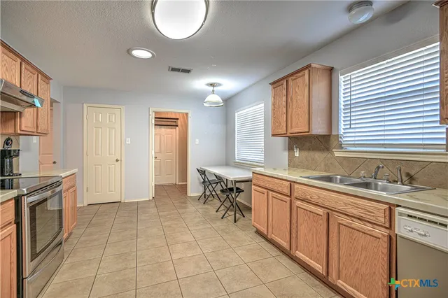 a kitchen with a sink window and cabinets