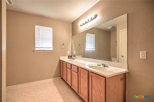a bathroom with a sink a mirror and a vanity