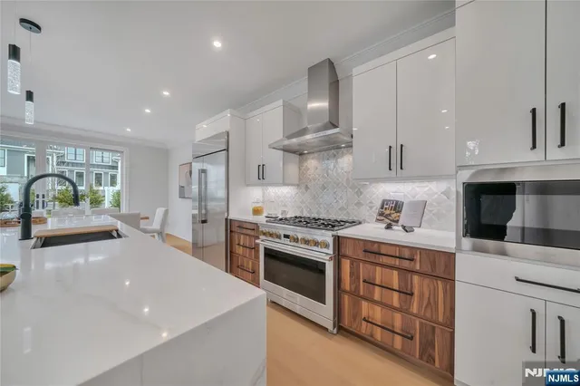 a kitchen with stainless steel appliances granite countertop a stove a sink and a refrigerator