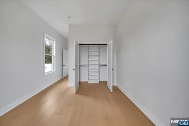 a view of a big room with wooden floor and windows
