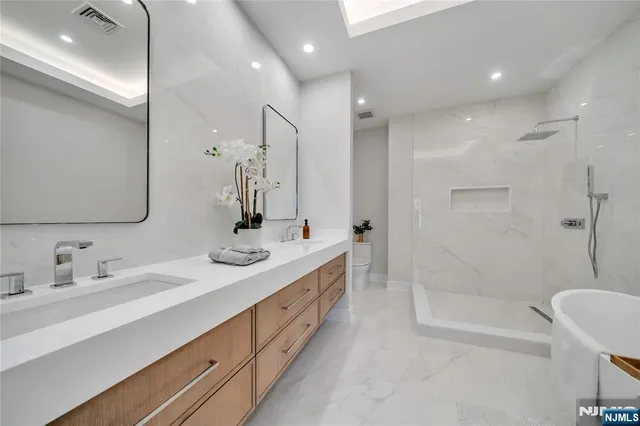 a bathroom with a double vanity sink mirror double and bathtub