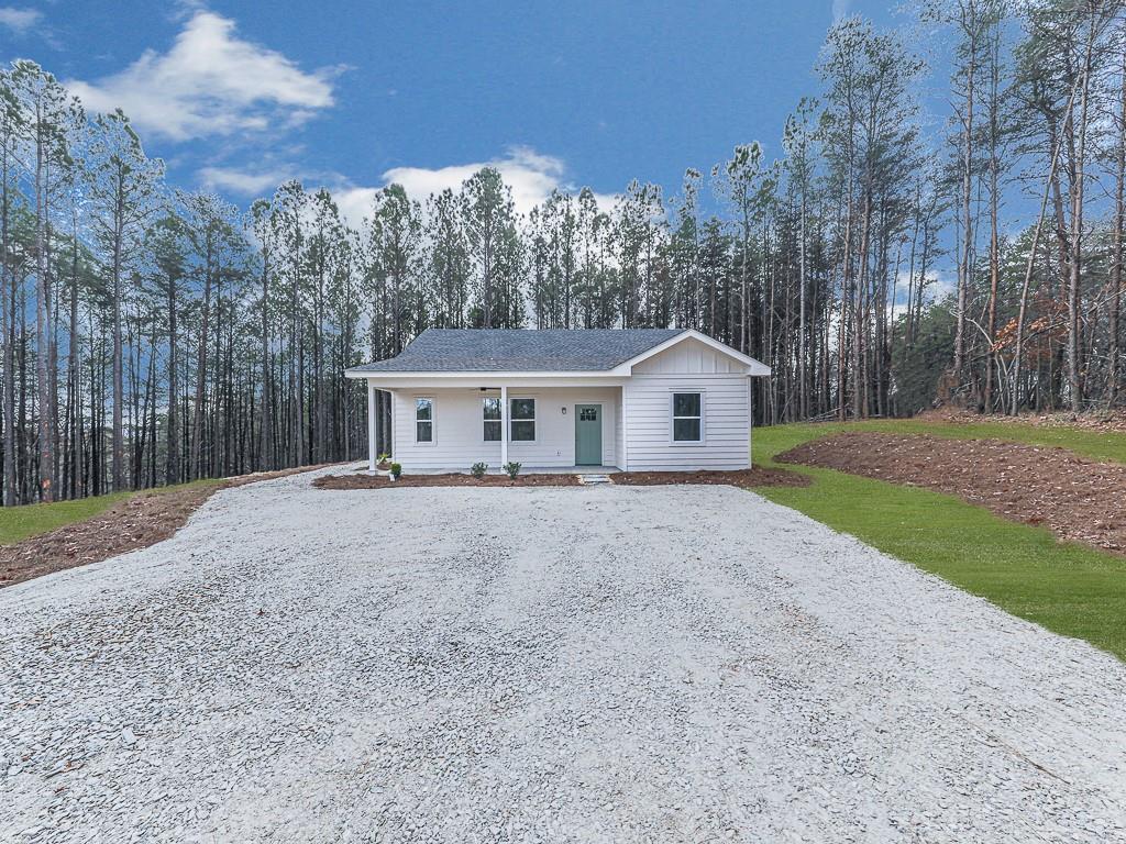 a view of a house with backyard and trees