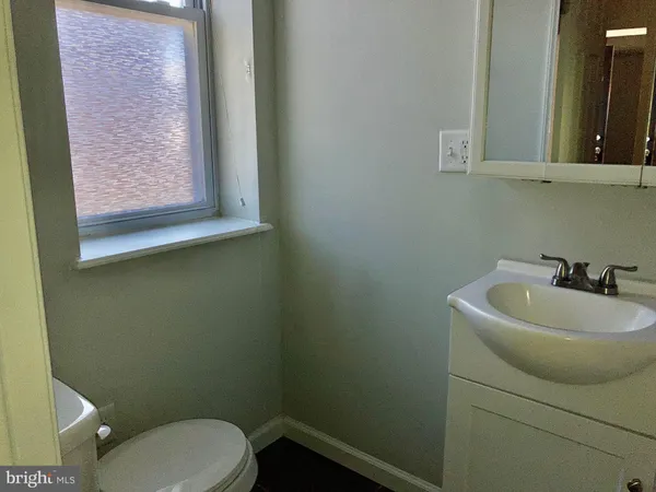 a bathroom with a sink mirror and toilet