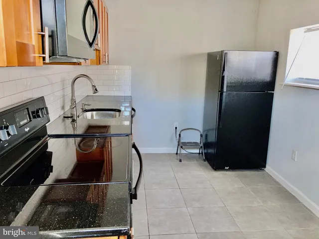a kitchen with a refrigerator and a stove