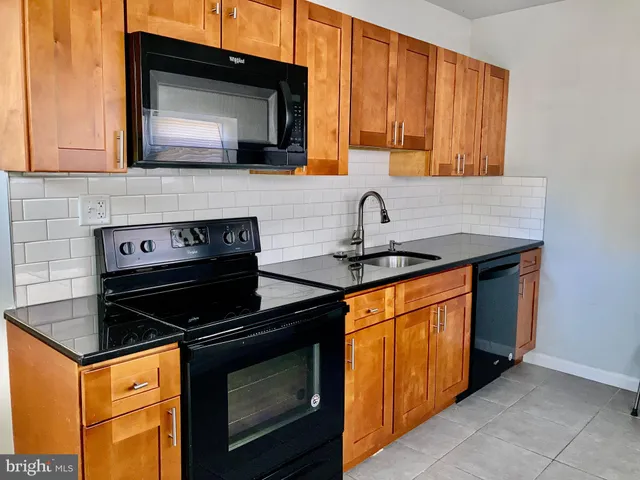 a kitchen with stainless steel appliances granite countertop a stove microwave and sink
