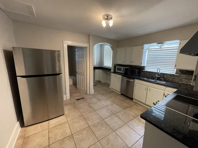 a kitchen with granite countertop a refrigerator and a sink