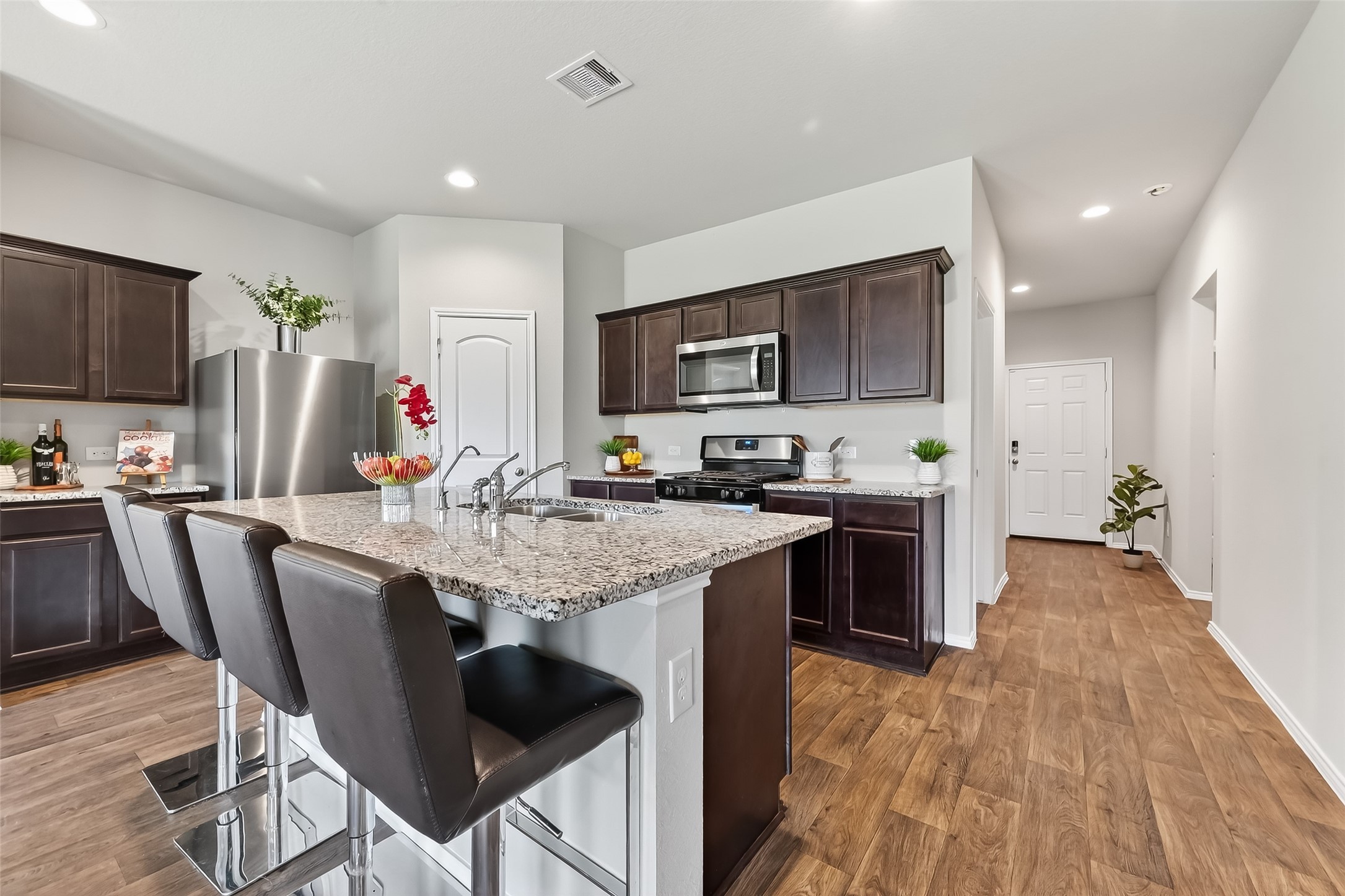 23511 Treeline Bluff Trail Spring Spring, TX 77373 - Photo 13 of 41 a kitchen with granite countertop a table chairs microwave and cabinets